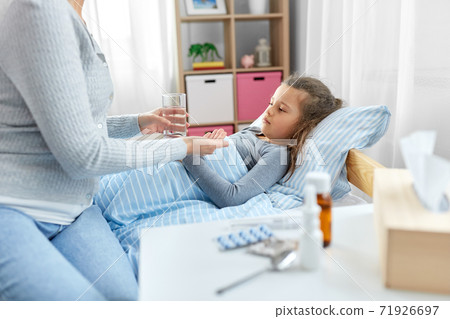 mother giving medicine to sick little daughter mother giving medicine to sick little daughter 71926697