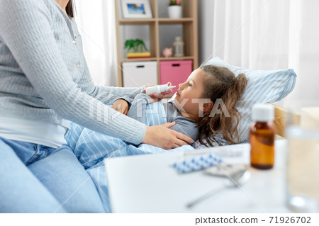 mother with nasal spray treats sick daughter mother with nasal spray treats sick daughter 71926702