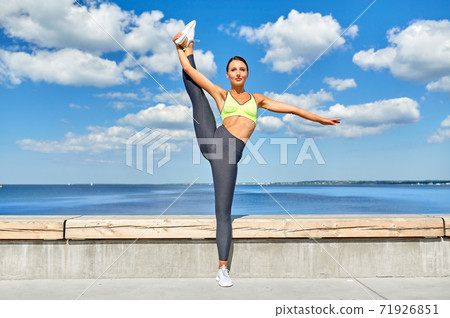 woman doing sports and stretching leg at seaside woman doing sports and stretching leg at seaside 71926851