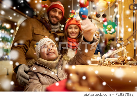 happy family buying souvenirs at christmas market 71927082