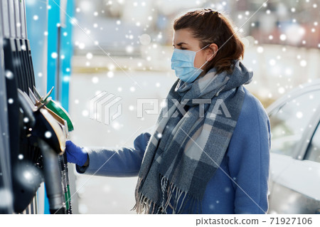 young woman wearing medical mask at gas station young woman wearing medical mask at gas station 71927106