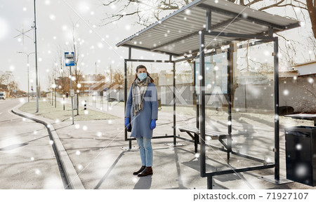 young woman wearing medical mask at bus stop young woman wearing medical mask at bus stop 71927107