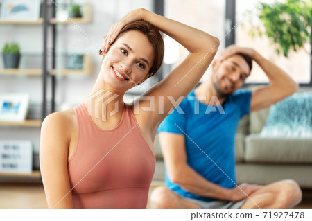 happy couple exercising at home 71927478