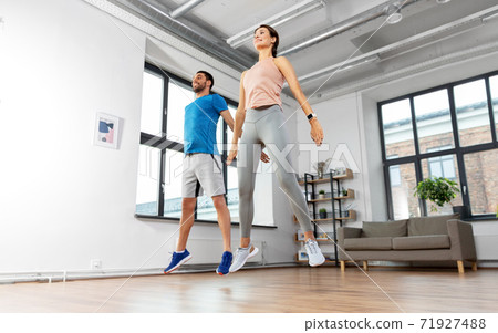 happy couple exercising and jumping at home happy couple exercising and jumping at home 71927488