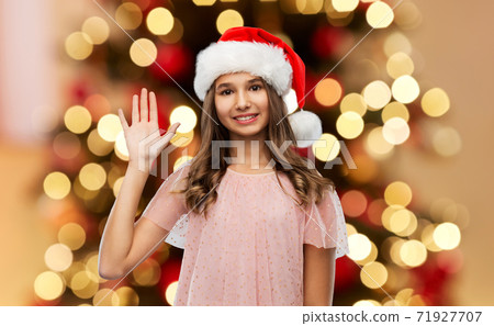 happy teenage girl waving hand on christmas 71927707