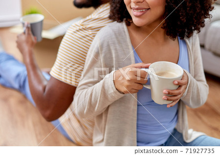 happy couple drinking coffee moving to new home happy couple drinking coffee moving to new home 71927735