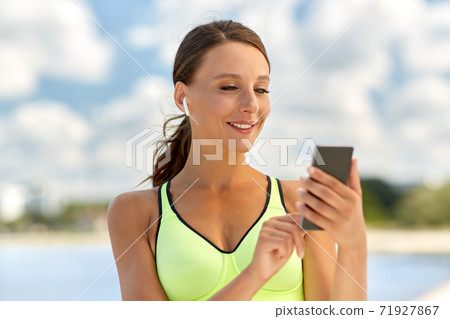 woman with earphones and smartphone doing sports woman with earphones and smartphone doing sports 71927867