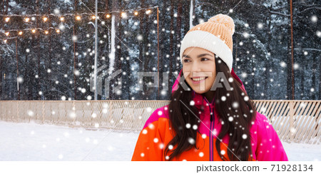 happy teenage girl over ice skating rink in winter 71928134