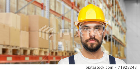 male worker or loader in helmet at warehouse male worker or loader in helmet at warehouse 71928248