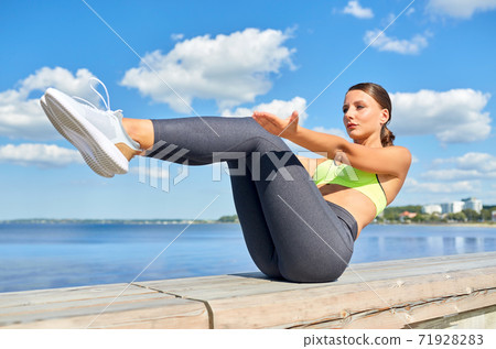 young woman exercising on sea promenade 71928283