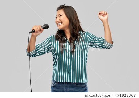 happy asian woman with microphone singing 71928368