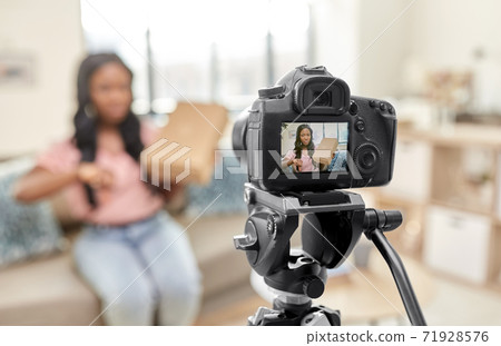 female video blogger with camera and box at home 71928576
