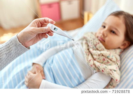 mother measuring temperature of sick daughter mother measuring temperature of sick daughter 71928878