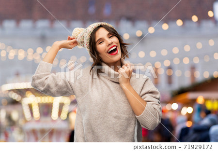 happy woman in hat and sweater at christmas market 71929172