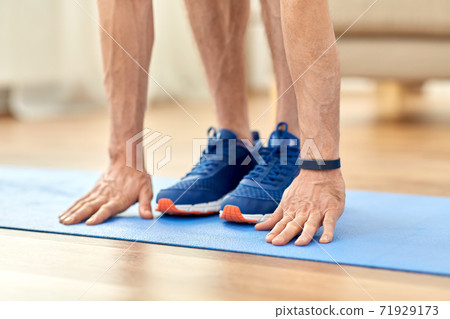 close up of male hands and feet on exercise mat close up of male hands and feet on exercise mat 71929173