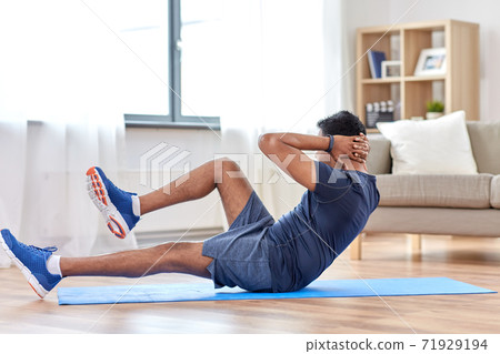 indian man making abdominal exercises at home 71929194