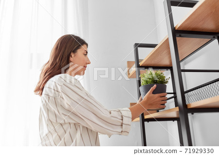 woman decorating home with flower or houseplant woman decorating home with flower or houseplant 71929330