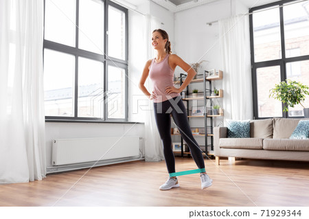 woman exercising with resistance band at home woman exercising with resistance band at home 71929344
