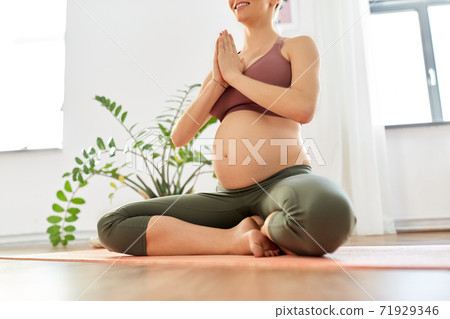 pregnant woman meditating at home pregnant woman meditating at home 71929346