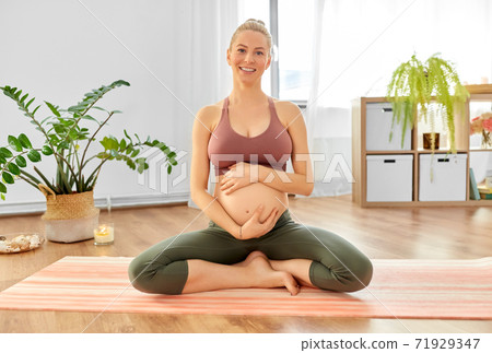 happy pregnant woman doing yoga at home happy pregnant woman doing yoga at home 71929347