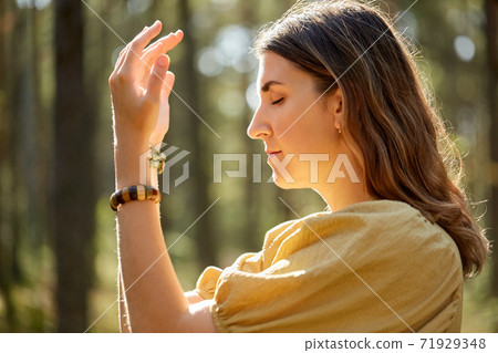woman or witch performing magic ritual in forest 71929348