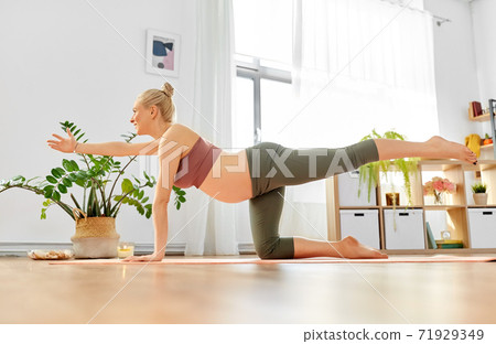 happy pregnant woman doing yoga table pose at home happy pregnant woman doing yoga table pose at home 71929349