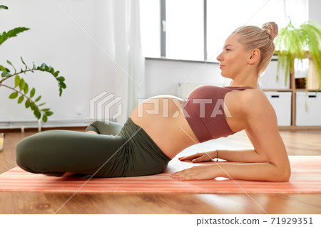 happy pregnant woman doing yoga at home happy pregnant woman doing yoga at home 71929351