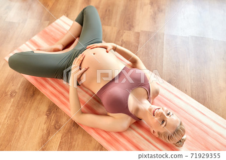 happy pregnant woman doing yoga at home 71929355