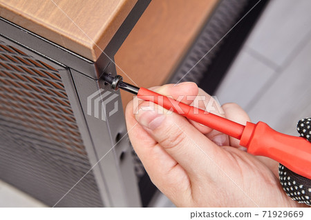 Handyman is assembling metal flat pack furniture using screwdriver. Handyman is assembling metal flat pack furniture using screwdriver. 71929669