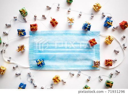 medical mask, boxes with gifts and Christmas decorations. 71931296