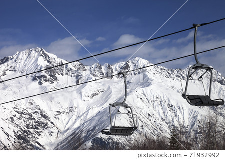 Chair-lift on ski resort and snowy mountains at nice sunny day Chair-lift on ski resort and snowy mountains at nice sunny day 71932992