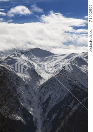 Snowy winter mountains and blue sky with sunlight clouds Snowy winter mountains and blue sky with sunlight clouds 71932993