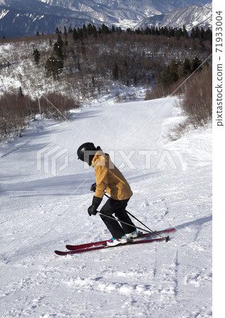Skier descent on snowy ski slope at sun winter day Skier descent on snowy ski slope at sun winter day 71933004
