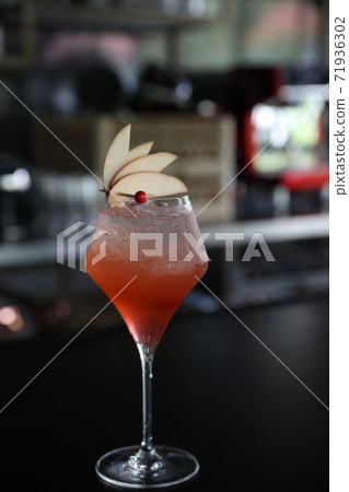 Pink Cocktail glass with ice at a bar counter 71936302