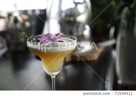 Pink Cocktail glass with ice at a bar counter 71936411