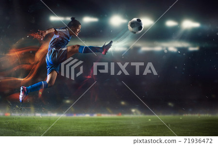 Young man football or soccer player kicking ball in jump at stadium - motion, action, activity concept. Flyer for ad, design. Young man football or soccer player kicking ball in jump at stadium - motion, action, activity concept. Flyer for ad, design. 71936472