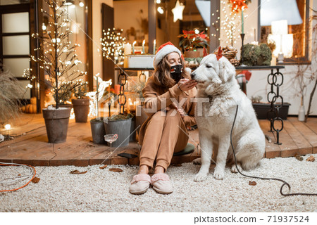 Woman on self-isolation celebrating New Year holidays with her dog at home 71937524