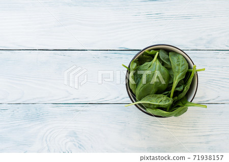 Closeup of spinach leaves on white wooden table 71938157