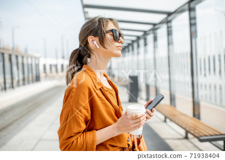 Woman waiting at the transport stop Woman waiting at the transport stop 71938404