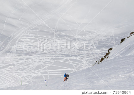Ssnowboarders before descend on freeriding trace 71940964
