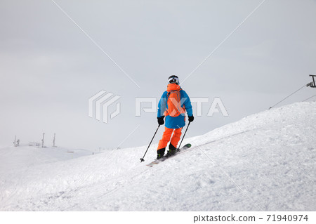 Skier before downhill on freeride slope and overcast misty sky Skier before downhill on freeride slope and overcast misty sky 71940974