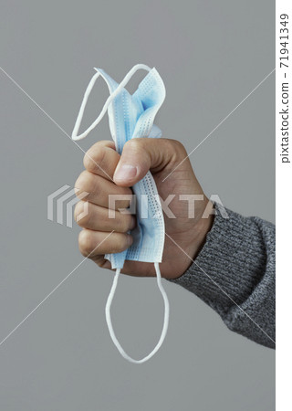 man squeezing a face mask in his hand man squeezing a face mask in his hand 71941349