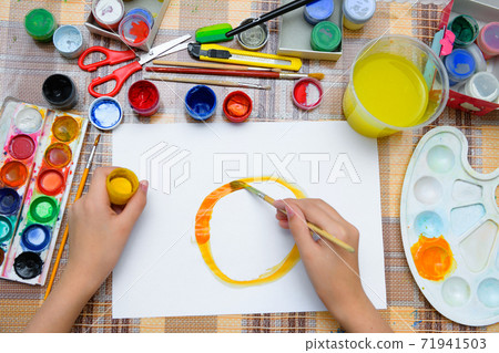 a girl drawing watercolor a big smiling sun on a blank white paper, artistic creation at home, makes creative artwork 71941503