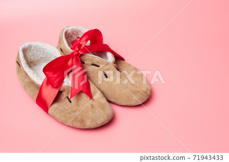 winter slippers with fur in a red ribbon, on a blue background, banner, copy space, mock up 71943433