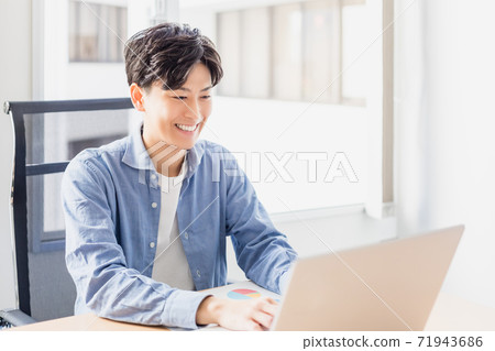 在辦公室的電腦上打字的年輕商人 在辦公室的電腦上打字的年輕商人 71943686