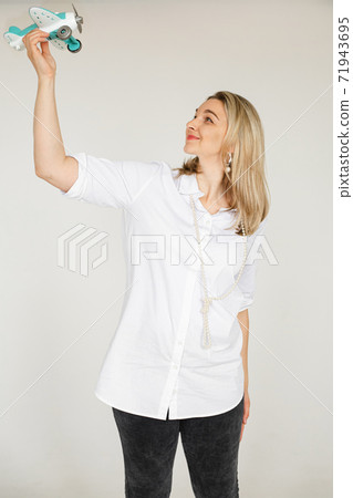 Happy girl with a toy plane in hand. 71943695