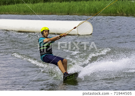 Teenager wakeboarding on a lake - Brwinow, Masovia, Poland Teenager wakeboarding on a lake - Brwinow, Masovia, Poland 71944505