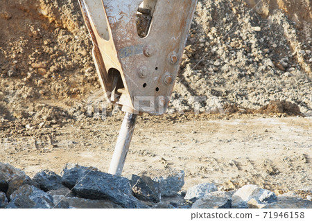 Work to crush concrete with heavy machinery at a waterway construction site 71946158