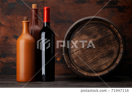 Wine bottles and old wooden barrel Wine bottles and old wooden barrel 71947116