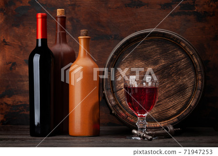 Wine bottles and old wooden barrel Wine bottles and old wooden barrel 71947253